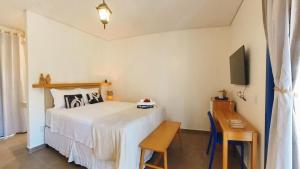a bedroom with a bed and a table and a television at Pousada Vila Pequi in Barreirinhas +138 photos