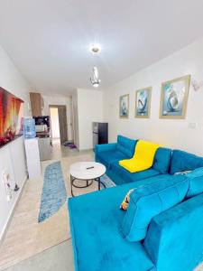 a living room with a blue couch and a table at Destiny homes in Rungiri