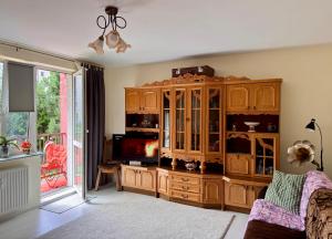un soggiorno con un grande centro di intrattenimento in legno di Kolobrzeska PRL Apartment with modern touch a Białogard