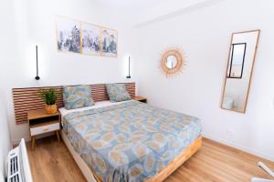 a bedroom with a bed and a mirror on the wall at joli & charmant au centre Millau in Millau