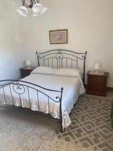 ein Bett in einem Schlafzimmer mit zwei Nachttischen und zwei Tischen in der Unterkunft La Piazzetta in Cantalupo nel Sannio