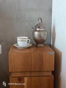 a tea pot and a cup on a wooden table at Cabana Ana Toplița in Topliţa