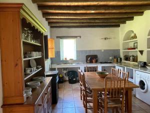 a kitchen with a table and chairs and a kitchen with a washer at La Casita de Platero in Los Marines