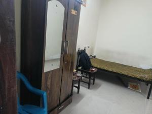 a room with a mirror and a bench and a chair at The PS Villa society in Pune