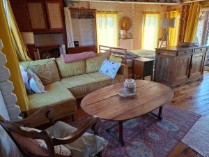 a living room with a couch and a table at Petit Chalet en Baie de Somme in Saint-Valery-sur-Somme