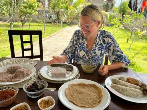 a woman sitting at a table with plates of food at Nesan’s villa in Trincomalee