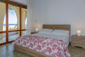 Un dormitorio con una cama y vista al mar. en Caminia - La baia incantata, en Caminia
