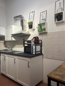 a kitchen with white cabinets and a microwave on a counter at Casin de Mori - intero appartamento 80mq- in Penna