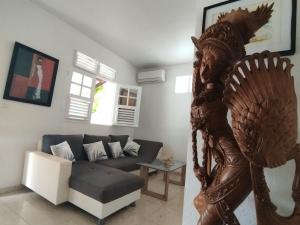 a living room with a couch and a statue at F2 pour une pause hors du temps in Ducos