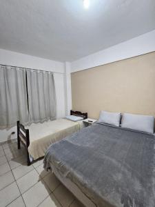a bedroom with two beds and a window at Apartamento Rua Teresa in Petrópolis