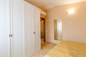 a bedroom with a bed and a large closet at Appartamento Mare Sardegna Porto San Paolo in Porto San Paolo