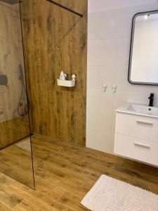 a bathroom with a shower and a sink at Apartament pod Świerkami in Pisz +7 photos