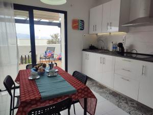 a kitchen with a table and chairs and a kitchen with white cabinets at Acera del Duende-Sardina in Gáldar
