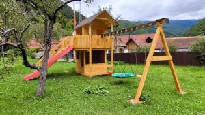 a playground with a play house and a slide at Pensiune agroturistica Casa cu Povesti Rau Sadului in Rau Sadului