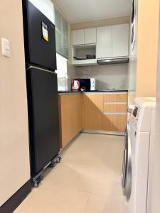 Punta Engañoにある3 Js Condo Rental 8NB Mactan Newtownの黒い冷蔵庫とコンロのあるキッチン