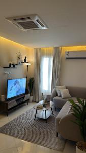a living room with a couch and a tv at 1BR, Living Room, Olaya in Al Khobar