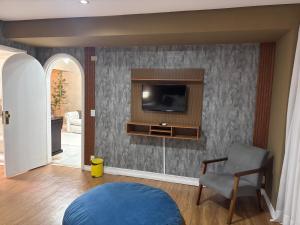 a living room with a tv on a wall at Fast10 Embaixador Hotel - Araújo Viana, Santa Casa, Palácio do Governo in Porto Alegre