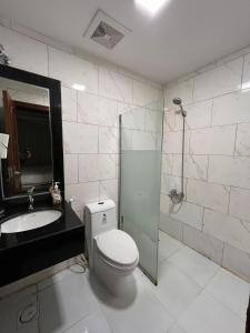a bathroom with a toilet and a sink and a shower at 1BR, Living Room, Olaya in Al Khobar +11 photos