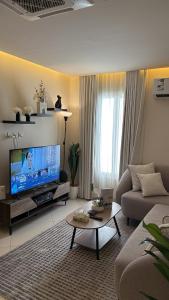 a living room with a couch and a tv at 1BR, Living Room, Olaya in Al Khobar
