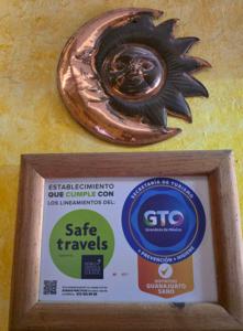 a sign in a frame with a statue on a wall at Hotel Sauces Celaya in Celaya