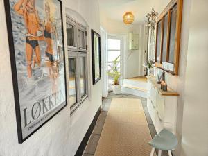 a hallway with pictures on the wall and a blue stool at Villa Vendel B&B in Løkken