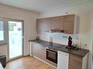 a kitchen with wooden cabinets and a large window at Ferienwohnung Missionshausstrasse in Sankt Wendel