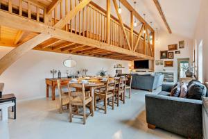 een eetkamer en een keuken met een houten tafel en stoelen bij Castlemans Coach House in Sedlescombe