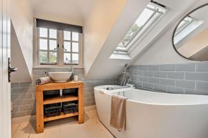 een badkamer met een wit bad en een wastafel bij Castlemans Coach House in Sedlescombe +25 foto's