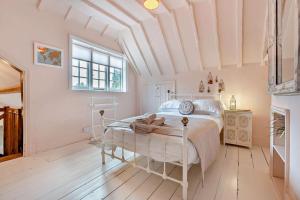 een slaapkamer met een wit bed in een kamer bij Castlemans Coach House in Sedlescombe