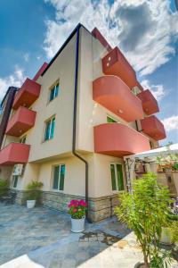 a building with red balconies on the side of it at Siena House - Free parking in Sozopol