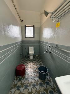 a small bathroom with a toilet and a sink at Dev's Resort & Restaurant in Ajgaon +11 photos