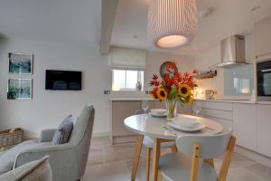 a kitchen with a table with a vase of flowers on it at Beech Cottage at Fir House in Cranbrook +8 photos