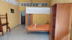 a room with a bed with a small pink animal on it at Studio Ylang - Vue mer & détente à Nosy Be in Nosy Be
