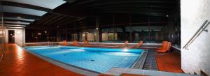 a large swimming pool with chairs in a building at Post-Hotel in Mittenwald