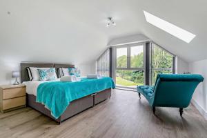 a bedroom with a large bed and a blue chair at Trevone in Saint Mawgan