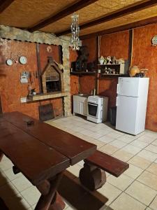 a kitchen with a wooden table and a refrigerator at Casa Cipri si Alex in Şimon