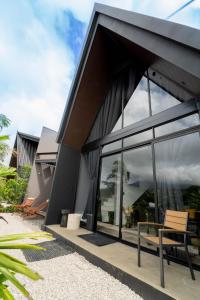 フォルトゥナにあるCozy Volcano View Stay Brand New & Hot Tubの大きな窓と外のベンチがある建物
