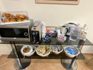 a table with a toaster and some baskets of bread at B&B & Residence Pozzo Misseo in Matera