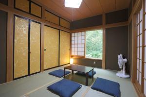 a room with a table and some windows at Lala's Riverside Cabin in Tsumagoi