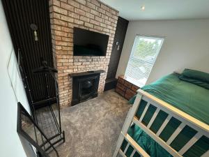 a bedroom with a fireplace and a bed and a television at City Centre Chic in Bangor +5 photos