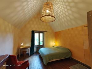 a bedroom with a bed and a chandelier at Les Studios Grenouilles in Chasseneuil-du-Poitou