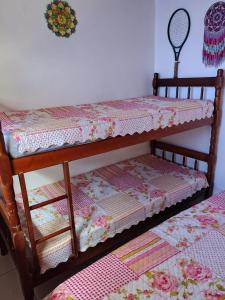 um beliche de madeira com uma colcha em Toca da Suzara Suíte 1 até 4 pessoas Piscina Rio e Mar num só lugar em Florianópolis