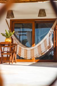 a hammock in a room with a chair and a window at Casa Nossa Preá in Prea