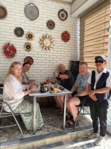 a group of people sitting around a table at Madina-Mehribon in Bukhara