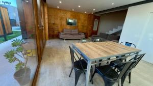 a dining room with a table and chairs and a couch at Apart Sei - Rada Tilly - in Rada Tilly