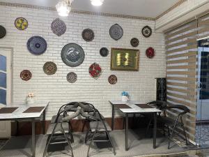a room with two tables and plates on the wall at Madina-Mehribon in Bukhara