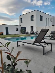 a house with a swimming pool in front of it at The Moment Luxury Suites in Parndorf