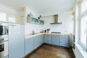 a kitchen with white cabinets and a wooden floor at Staal House in Amsterdam