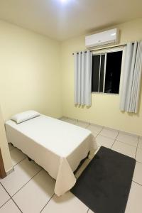a white bedroom with a bed and a window at Apartamento COP 30 in Ananindeua +14 photos
