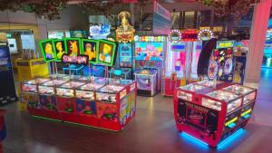 a room with arcade games and video game machines at Abi Summer Breeze - West Sands in Selsey